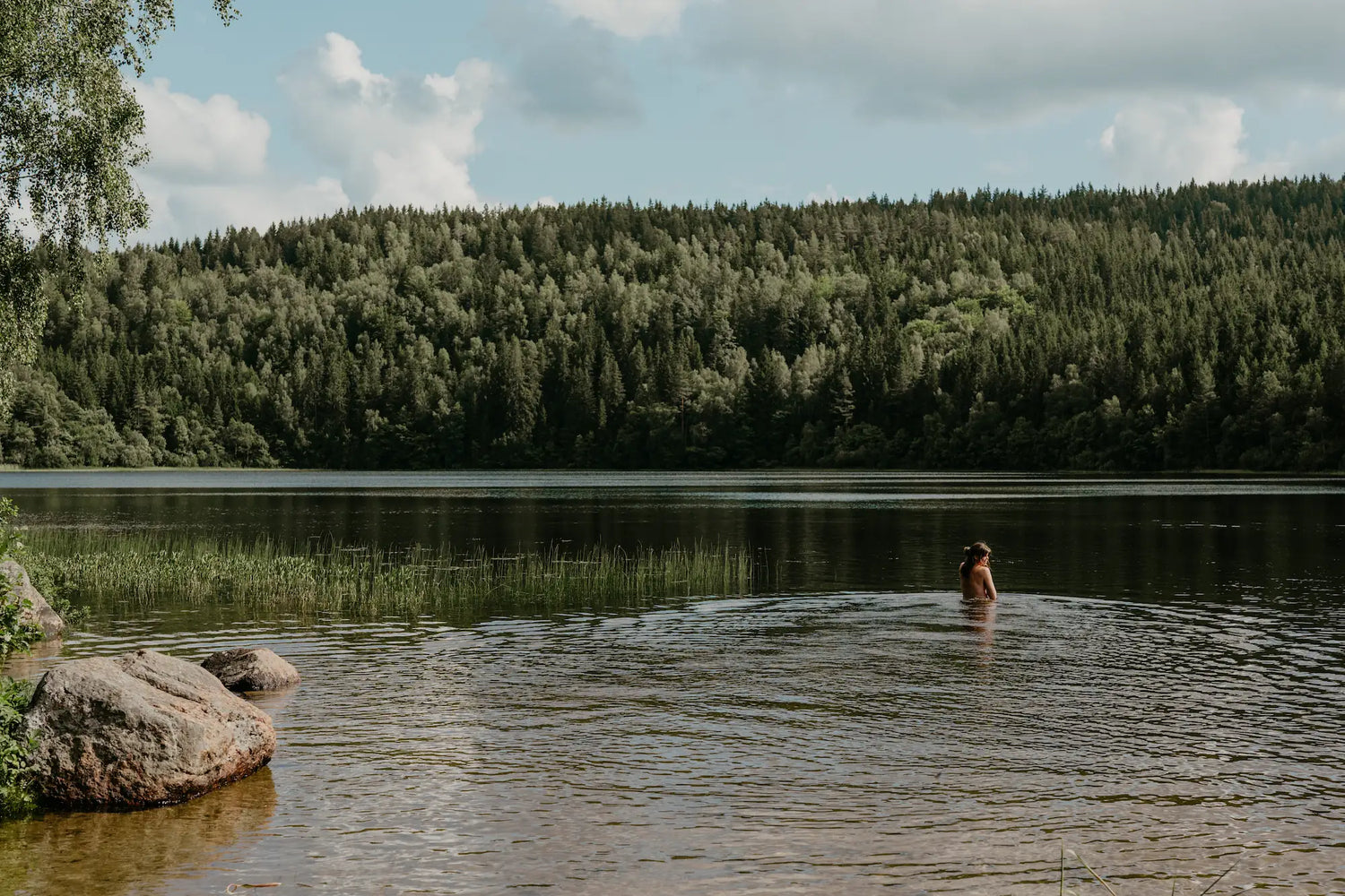 Tjej badar i sjö på sommaren