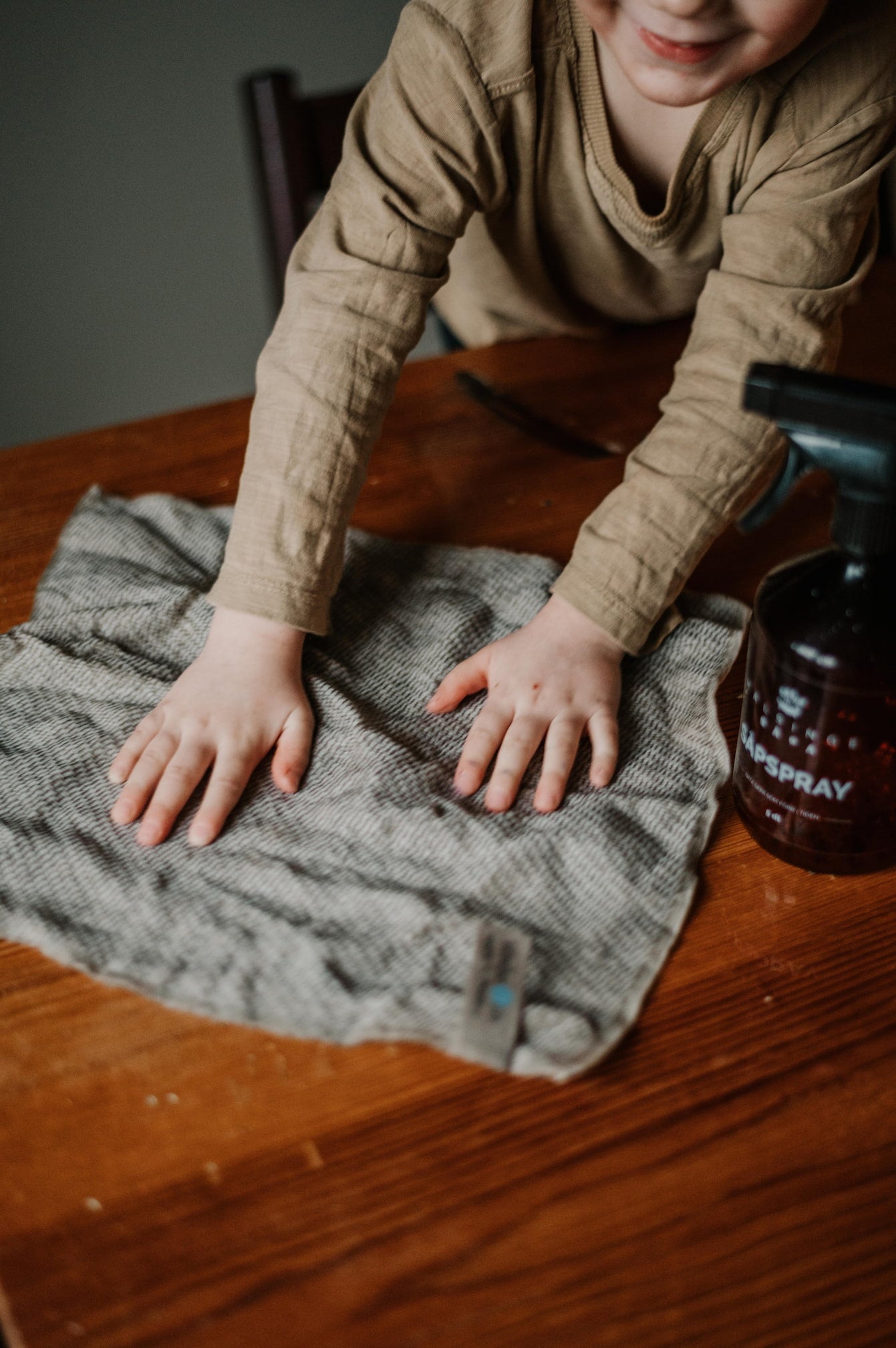ett barn håller på en handduk på ett bord
