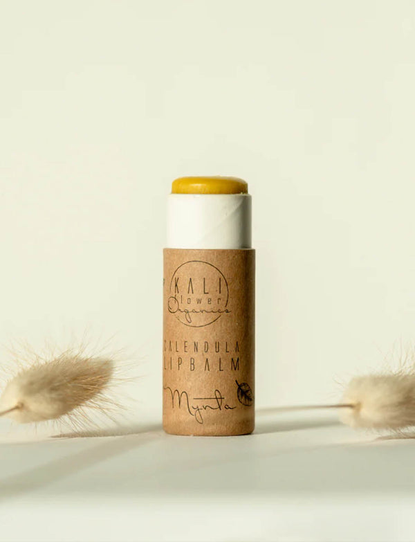 Kaliflower Organics läppcerat öppnat, mot ljus bakgrund