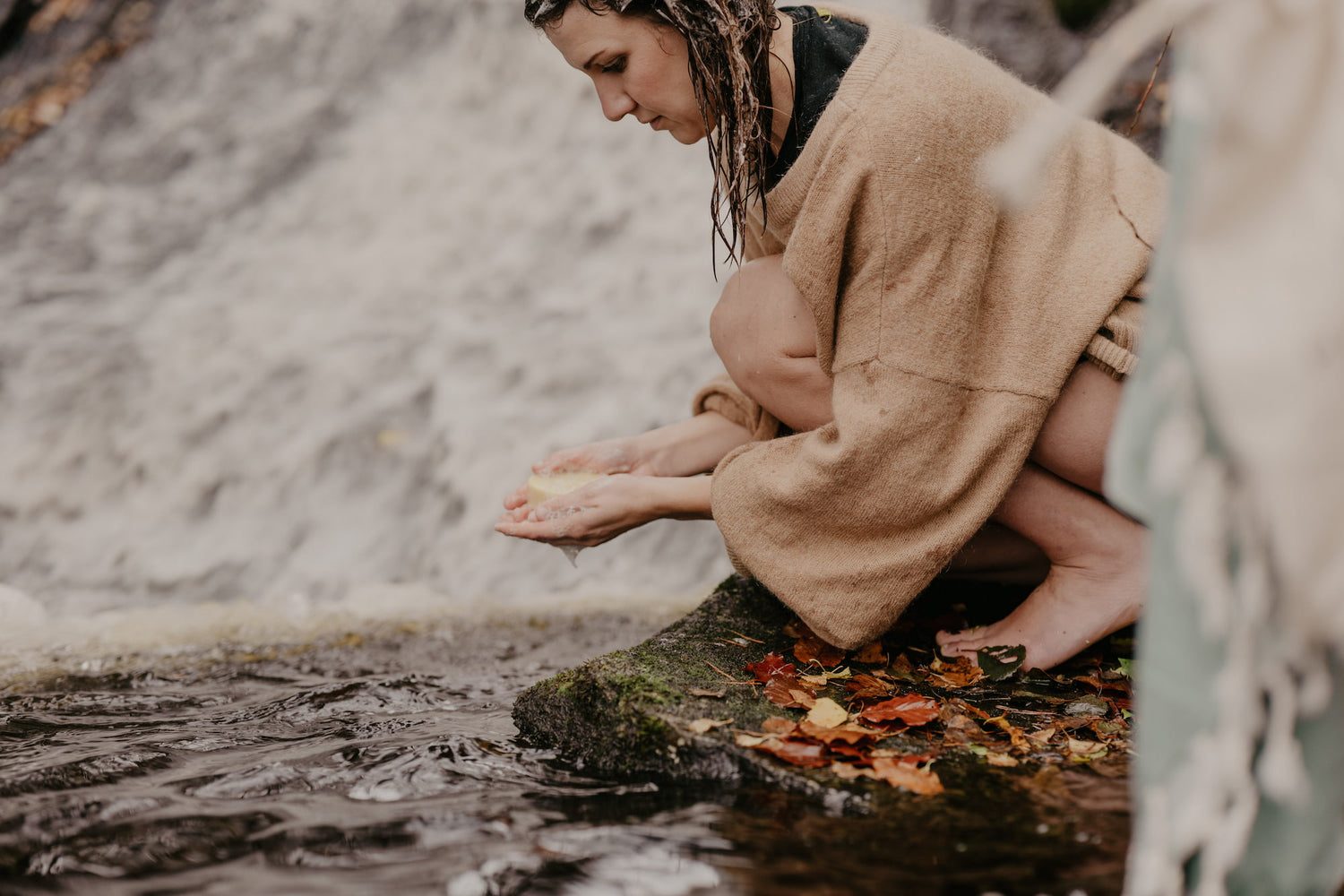 en tjej står vid en bäck och tvålar sig