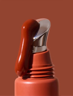 INIKA Tinted Lip Serum i nyansen Rosewood med serum på spetsen